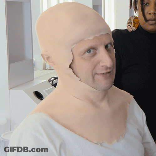 A Man With A Wig On His Head Is Standing Next To Another Man GIF