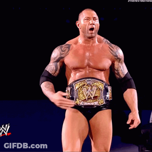 A Man With A Wrestling Belt Is Standing In Front Of A Screen That Says ' Wrestlemania ' On It GIF