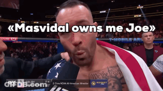 A Man With An American Flag Wrapped Around His Chest Is Being Interviewed By Colby Covington GIF