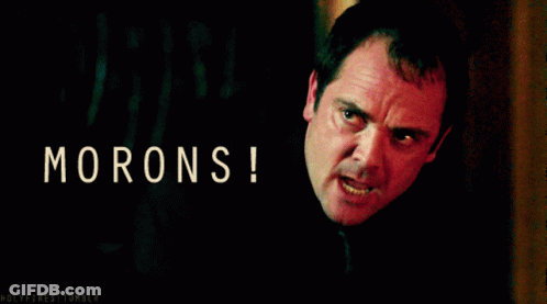 A Man With An Angry Look On His Face With The Words Morons Written Above Him GIF
