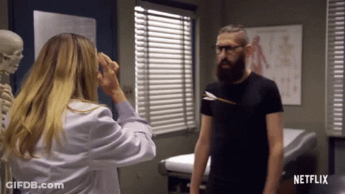 Man With Arrow In Shirt Standing Next To Woman And Skeleton GIF