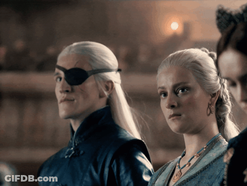 A Man With An Eye Patch And A Woman In A Blue Dress GIF