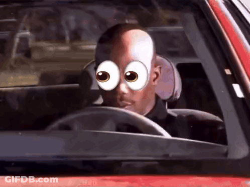 A Man With Big Eyes Is Driving A Red Car . GIF