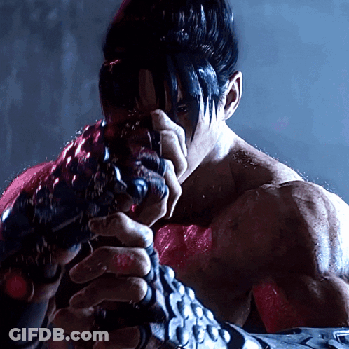 A Man With Black Hair Is Holding A Gun GIF