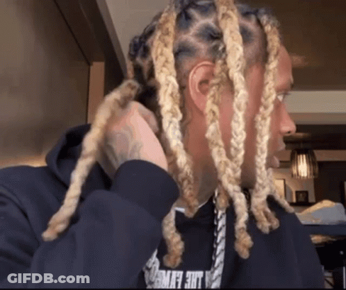 A Man With Blonde Dreadlocks Is Wearing A Black Hoodie That Says Lace Flying GIF
