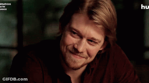 A Man With Blonde Hair And A Beard Is Smiling . GIF