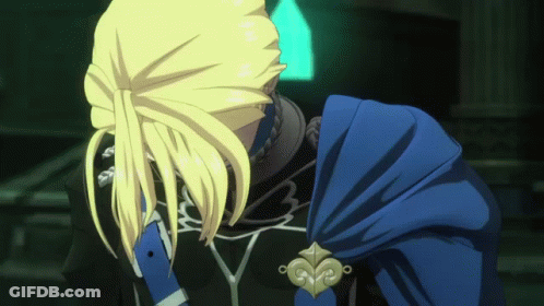 A Man With Blonde Hair And A Blue Cape Looks Down GIF