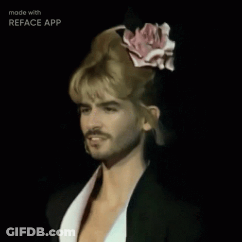 A Man With Blonde Hair And A Pink Rose In His Hair Is Made With Reface App GIF