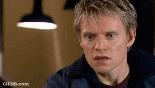 A Man With Blonde Hair And Blue Eyes Looks At The Camera GIF