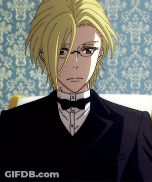 A Man With Blonde Hair And Glasses Is Wearing A Tuxedo GIF