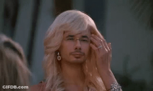 A Man With Blonde Hair And Glasses Is Wearing A Wig . GIF