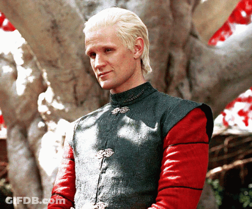 A Man With Blonde Hair And Red Sleeves Is Wearing A Green Vest GIF