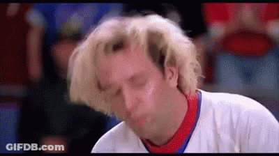 A Man With Blonde Hair Is Making A Funny Face While Wearing A White Shirt . GIF