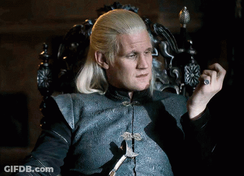 A Man With Blonde Hair Is Sitting In A Chair Holding A Sword GIF