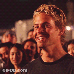 A Man With Blonde Hair Is Smiling In A Crowd GIF