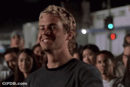 A Man With Blonde Hair Is Smiling In A Crowd Of People GIF