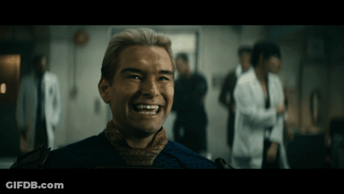A Man With Blonde Hair Is Smiling In A Room GIF