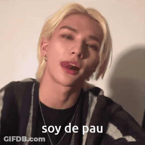 A Man With Blonde Hair Is Sticking His Tongue Out And The Words Soy De Pau Are Visible GIF
