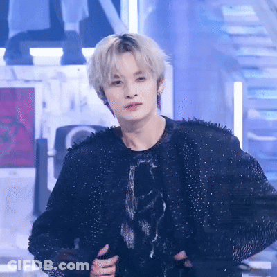 A Man With Blonde Hair Is Wearing A Black Jacket And A Black Shirt GIF
