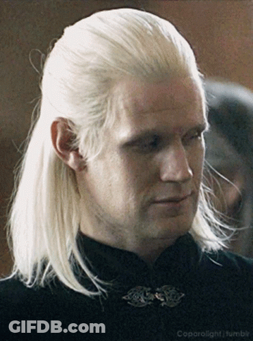 A Man With Blonde Hair Is Wearing A Black Shirt And A Black Collar GIF