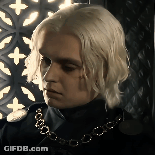 A Man With Blonde Hair Is Wearing A Necklace GIF