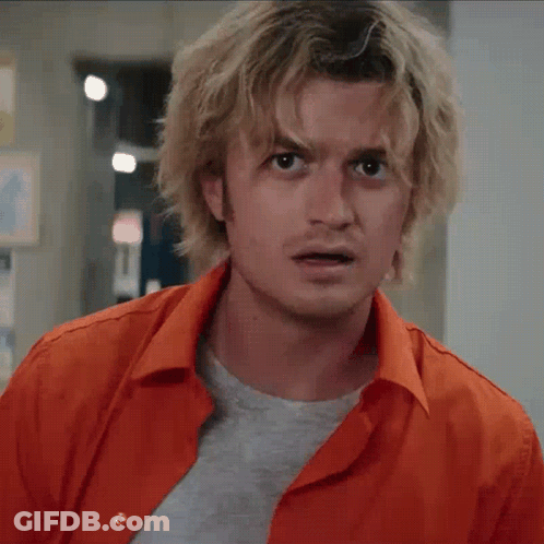 A Man With Blonde Hair Is Wearing An Orange Shirt And A Grey T-Shirt GIF