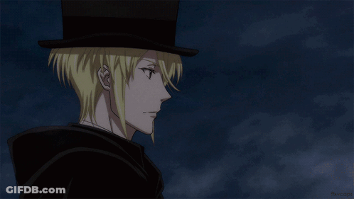 A Man With Blonde Hair Wearing A Top Hat And A Cape GIF