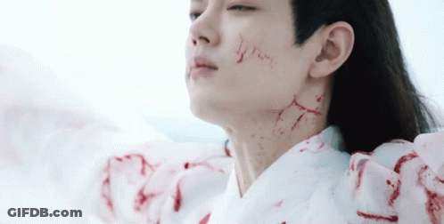 A Man With Blood On His Face And Neck Is Wearing A White Robe . GIF