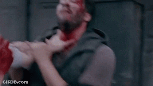 A Man With Blood On His Face Is Being Hit By Another Man . GIF