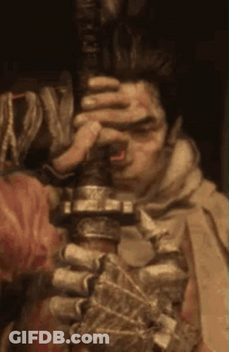 A Man With Blood On His Face Is Holding A Sword . GIF
