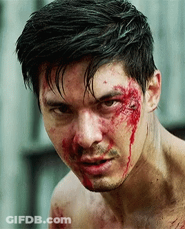 A Man With Blood On His Face Is Looking At The Camera GIF