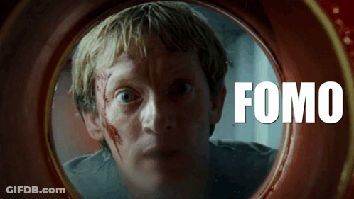 A Man With Blood On His Face Is Looking Through A Hole With The Word Fomo On It GIF