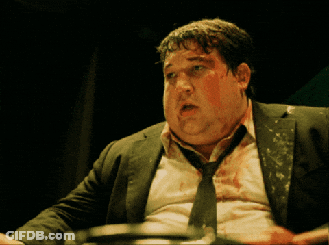 A Man With Blood On His Face Is Wearing A Black Suit And Tie GIF