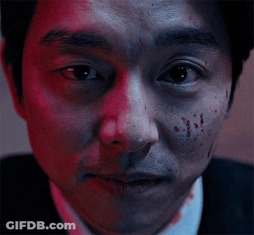 A Man With Blood On His Face Looks At The Camera GIF