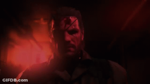 A Man With Blood On His Face Stands In A Dark Room GIF