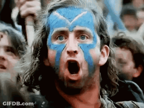 A Man With Blue And White Paint On His Face Is Making A Surprised Face . GIF
