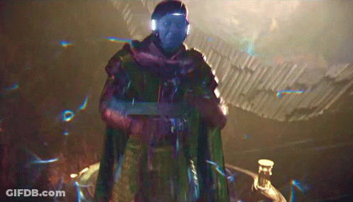 A Man With Blue Eyes And A Scarf Around His Neck Is Standing In A Dark Room GIF