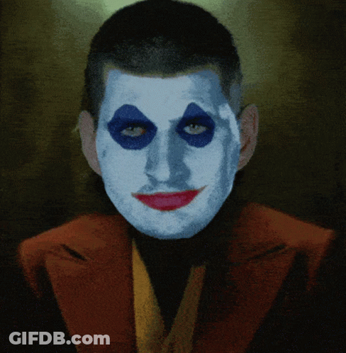 A Man With Blue Eyes And Red Lips Is Wearing A Red Jacket GIF