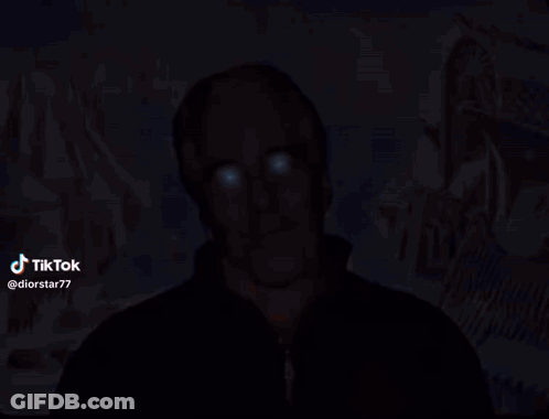 A Man With Blue Eyes Is Standing In Front Of A Painting With A Star Of David In The Background GIF