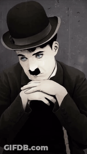 A Man With Blue Eyes Wearing A Bowler Hat And A Mustache GIF