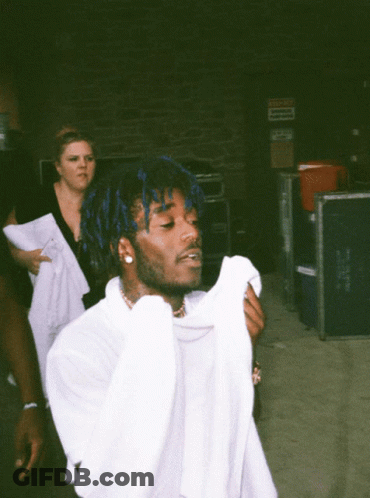 A Man With Blue Hair Is Holding A White Shirt GIF