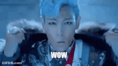 A Man With Blue Hair Is Wearing A Fur Coat And Holding A Microphone . GIF