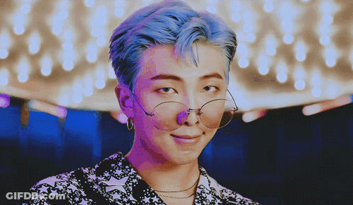 A Man With Blue Hair Wearing Glasses And Earrings GIF