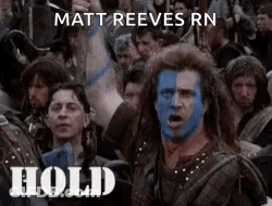 A Man With Blue Paint On His Face Is Standing In Front Of A Crowd Of People And Says Hold . GIF