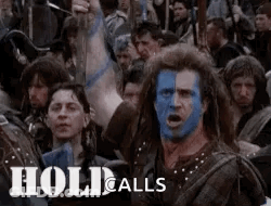 A Man With Blue Paint On His Face Is Surrounded By A Crowd Of People . GIF