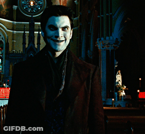 A Man With Blue Paint On His Face Stands In Front Of A Building GIF
