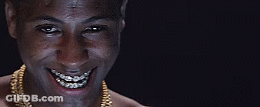 A Man With Braces On His Teeth Is Smiling And Wearing A Gold Chain . GIF