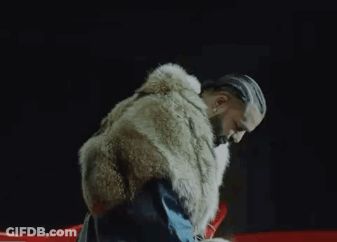 A Man With Braids Is Wearing A Fur Coat And A Blue Jacket . GIF