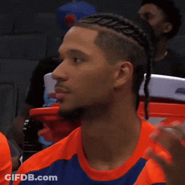 A Man With Braids On His Head Is Wearing A Blue And Orange Shirt GIF