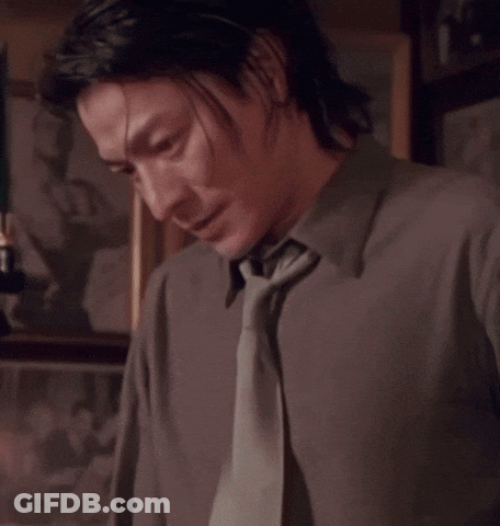 A Man With Chinese Writing On His Shirt And Tie GIF
